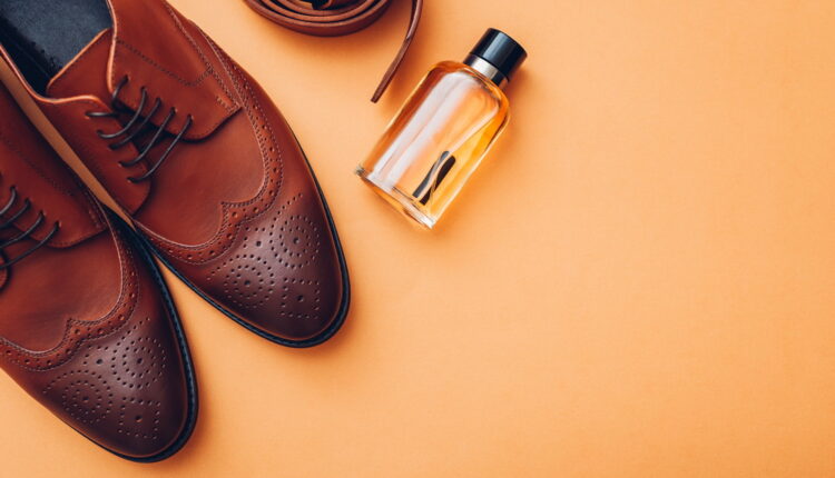 Oxford male brogues shoes with accessories. Men’s fashion. Classical brown leather footwear with belt and perfume.